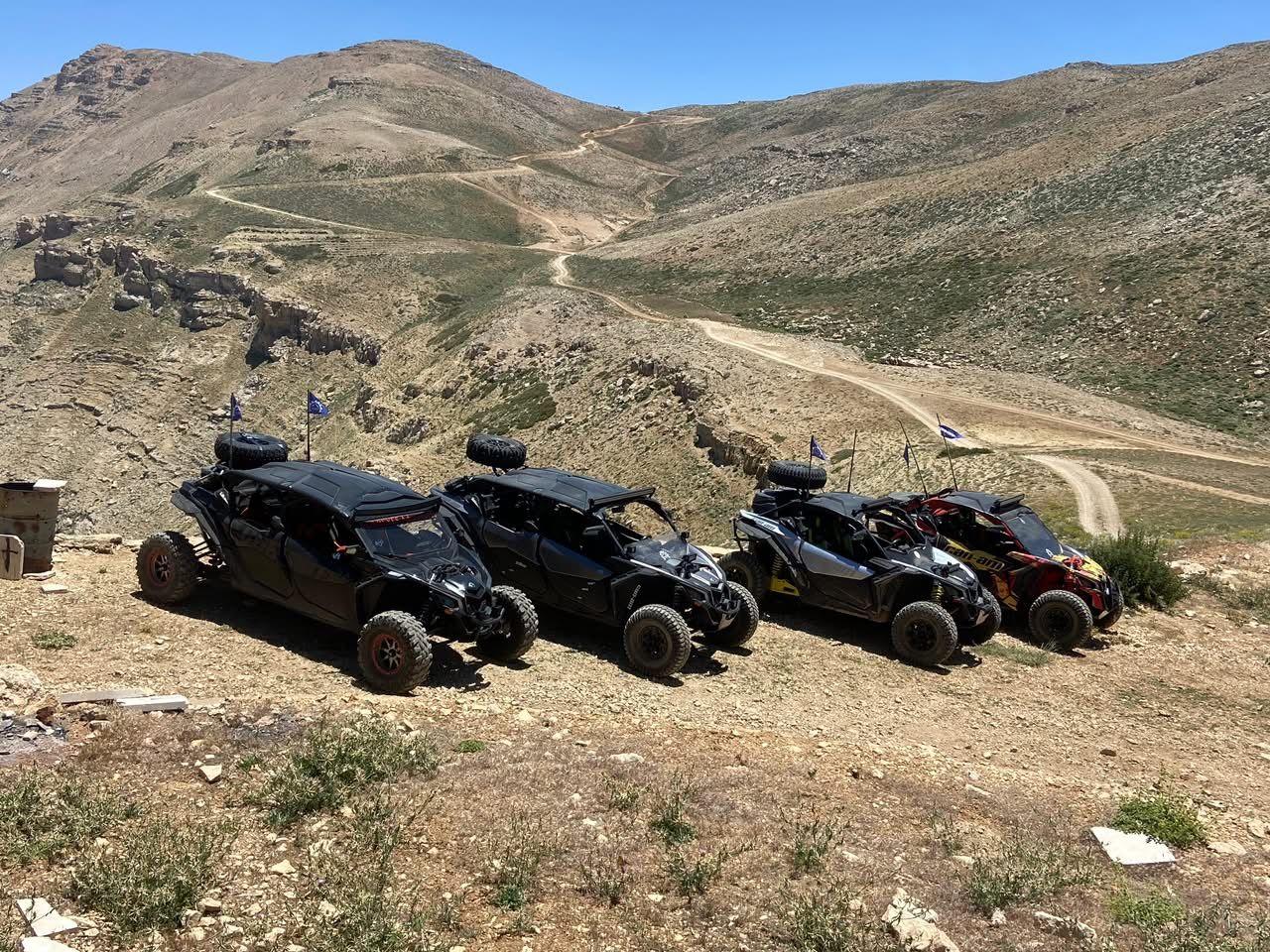 Four X3s parked on a ridge overlooking trails